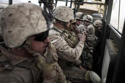 U.S. Marines from the First Battalion Eighth Marines Alpha Company smoke while riding on the back of a vehicle in southern Afghanistan's Helmand province, February 27, 2011