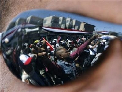 Anti-government protesters are reflected on the sunglasses of a fellow protester during a demonstration demanding the ouster of Yemen's President Ali Abdullah Saleh outside Sanaa University February 28, 2011