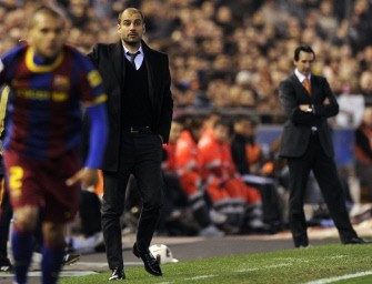 Barcelona's coach Josep Guardiola (C) watches the Spanish league football match opposing Valencia and Barcelona at Mestalla stadium in Valencia on March 2, 2011. Barcelona won 1-0. AFP