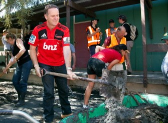 New Zealand Prime Minister John Key helps out the Farmy Army (New Zealand Volunteer Farmers) at Linwood College as he surveys earthquake damage in the Christchurch suburb of Bexley on March 4, 2011. AFP