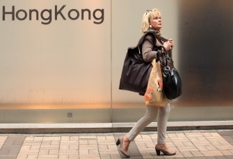 AFP file - File photo taken on December 13, 2010 shows a woman walking past a Hong Kong sign in a street in Hong Kong.