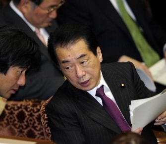 Japanese Prime Minister Naoto Kan (R) chats with his aide during the upper house's budget committee session at the National Diet in Tokyo on March 7, 2011, one day after his foreign minister Seiji Maehara resigned. AFP