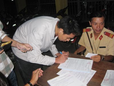 An illegal racer signs his violation report. (PhotoL SGGP)