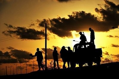 Libyan rebel fighters are silhouetted at sunset in the oil centre of Brega.