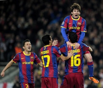 Lionel Messi (R-up) is congratulated by his teammates during their Champions League match FC Barcelona vs Arsenal on March 8, 2011 at Camp Nou stadium in Barcelona. AFP