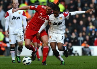 Liverpool's forward Andy Carroll (C) vies with Manchester United's defender Patrice Evra during the English Premier League football match between Liverpool and Manchester United at Anfield, Liverpool on March 6, 2011. AFP