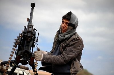 A Libyan rebel fighter struggles to reload his machine gun during clashes with forces loyal to Moamer Kadhafi, just few kilometers outside the oil town of Ras Lanuf. AFP