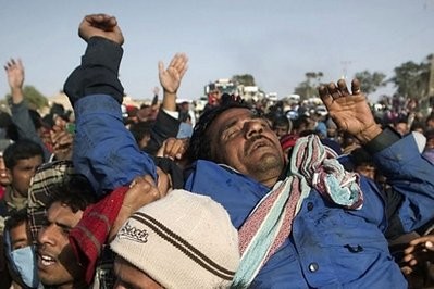 A unconscious refugee (C) is carried as they demonstrate to ask for food and aid, at the Choucha refugee camp, near the Tunisian border town of Ras Jdir