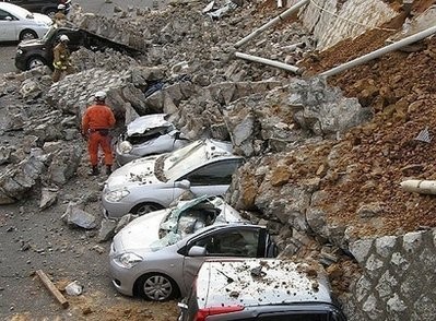Vehicles are crushed by a collapsed wall at a carpark in Mito city in Ibaraki prefecture after a massive earthquake rocked Japan