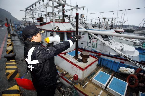 A staff member evacuates fishermen to safe area in response to a tsunami alarm in Keelung of Taiwan, southeast China, March 11, 2011. Following a strong earthquake in Japan Friday, Taiwan had earlier issued a tsunami alarm, but later sounded the all clear after foreseeing no disasters despite several small tsunamis in the afternoon