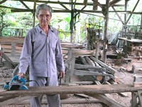 Nguyen Van Ngoi is planning a chunk of timber in his backyard (Photo: tim.vietbao.vn)