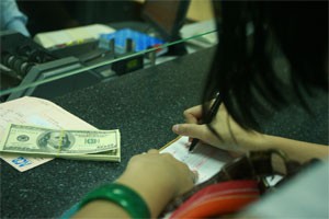 A client lists types of dollars before selling to Asia Commercial Bank. Economists propose to limit licensing foreign currency exchange shops (Photo:Minh Tri)
