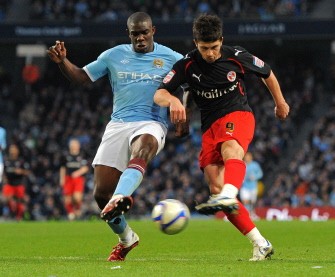 Reading's striker Shane Long (R) shoots past Manchester City's defender Micah Richards during the FA Cup quarter-final between Manchester City and Reading on March 13, 2011. AFP