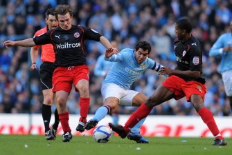 Manchester City's striker Carlos Tevez (2nd R) vies with Reading's Jay Tabb (L) and Mikele Leigertwood (R) during the FA Cup quarter-final. AFP