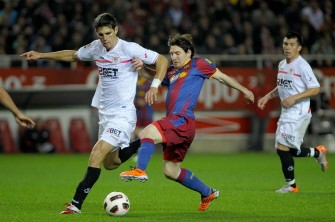 Sevilla's Federico Facio (L) vies for the ball with Barcelona's Lionel Messi (C) during their Liga match on March 13, 2011 in Sevilla. AFP