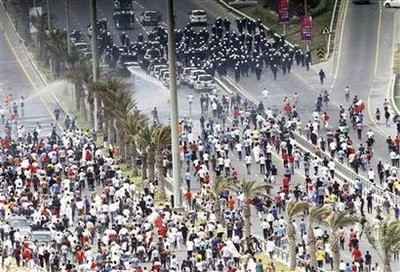Anti-government protesters confront riot police on a flyover near the Pearl Square in Manama, March 13, 2011.
