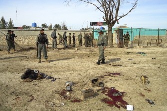 Afghan security personnel are seen at the site of a suicide bomb attack in Kunduz on March 15, 2011. AFP