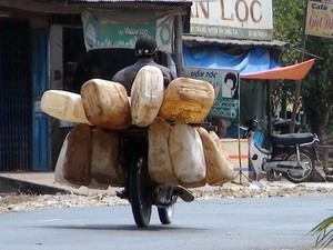 Man carrying empty cans to buy fuel. (Photo:VNA)