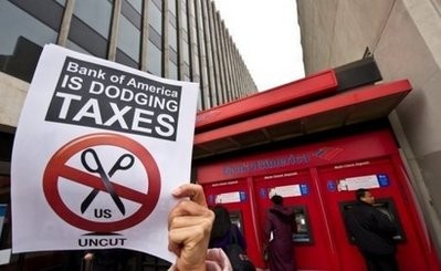 AFP - A protester holds a sign in front of a Bank of America branch in Washington in February during a demonstration against the bank having not paid any federal income taxes in 2009 despite having received $45 billion in bailout money from the government in 2008 and 2009.