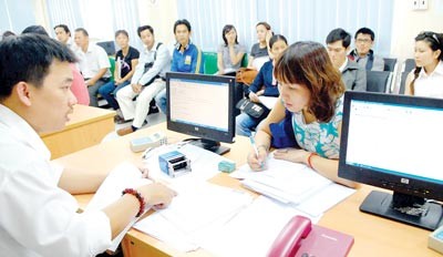A woman is asking for guidelines on income taxes at the HCMC Tax Department. Many taxpayer complain the taxable income threshold and dependent deduction are too low (Photo:Kim Ngan)