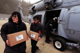 AFP - This handout photo taken on March 15, 2011 by the US Navy shows Japanese citizens moving food and water out of an US HH-60H Sea Hawk helicopter during rescue operations in northern Japan.