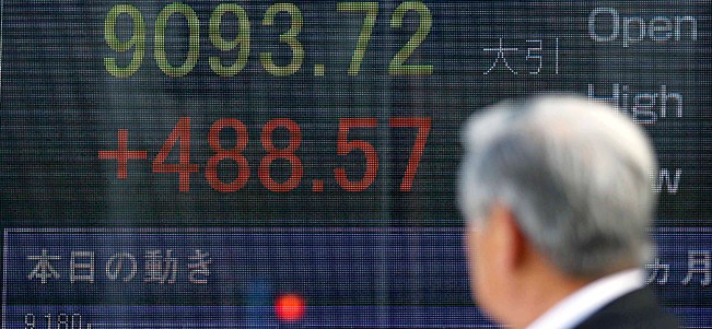 A man looks at the stock price board outside a securities firm branch Wednesday, March 16, 2011 in Tokyo.