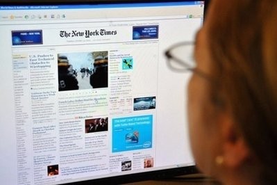 AFP - A woman reads the front page of the New York Times on the Internet, 2010 in Washington, DC.