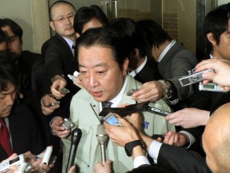 Japanese Finance Minister Yoshihiko Noda (C) speaks to reporters announcing that finance ministers from the G7 group of top economies and central bankers will hold teleconference talks, at his office in Tokyo on March 17, 2011. AFP