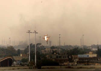 A Libyan jet bomber crashes after being shot down in Benghazi on March 19, 2011 as Libya's rebel stronghold came under attack, with at least two air strikes and sustained shelling of the city's south sending thick smoke into the sky.