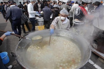Evacuees receive Tonjiru, a pork and vegetable soup, after voluntees prepared over 2,000 servings at a shelter in Koriyama, Fukushima prefecture on March 20, 2011. AFP