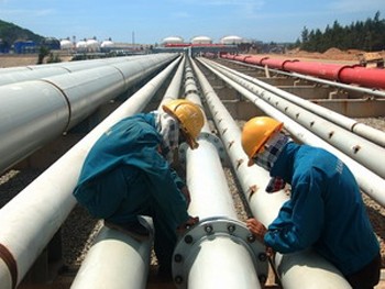 Workers examine pipes at the Dung Quat Oil Refinery in Quang Ngai (Photo: VNA)