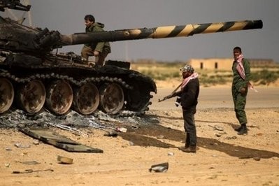 Libyan rebels gather around a burning T-72 tank belonging to forces of Libyan leader Moamer Kadhafi in Shat al-Bedin 50 kms West of Benghazi. AFP