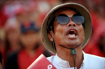 A Thai anti-government Red Shirt protester sings the national anthem during a rally in downtown Bangkok on March 19, 2011. AFP