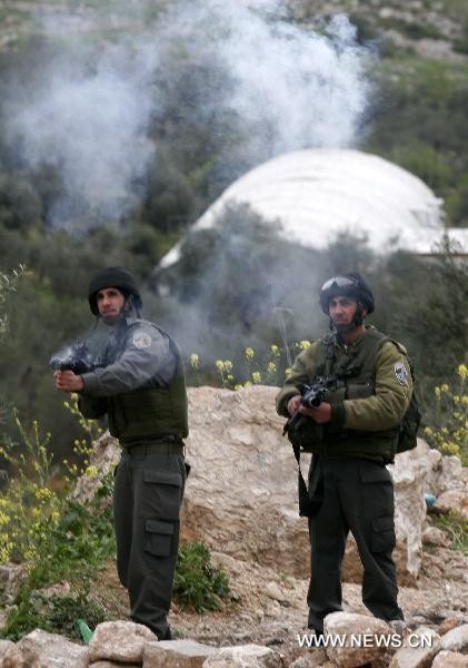Israeli soldiers fire tear gas grenades towards Palestinian protestors during clashes in the West Bank village of Awarta near Nablus, March 22, 2011