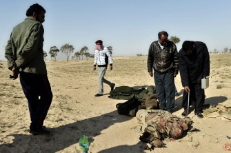 Libyans gather around the body of a dead pro-Kadhafi fighter in the strategic oil town of Ajdabiya whose control was seized by rebels from Colonel Moamer Kadhafi's forces on March 26, 2011. AFP