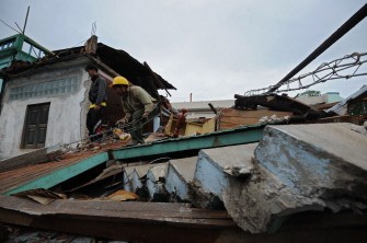 AFP - A survivor of the March 24 earthquake goes through the rubble of his destroyed house, in Tarlay, northeastern Myanmar on March 27, 2011. AFP