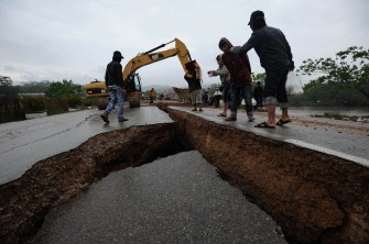 AFP - Workers use an excavator to repair a road cracked in the March 24 earthquake, near Tarlay, northeastern Myanmar on March 27, 2011. Xayaburi is not very far from the quake-hit region.