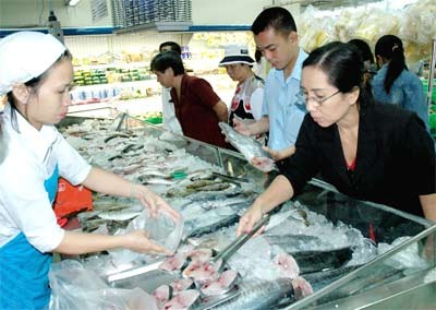 Shoppers check out seafood at a supermarket in Ho Chi Minh City. Seafood is a new addition to the list of the price stabilization program this year (Photo: SGGP).
