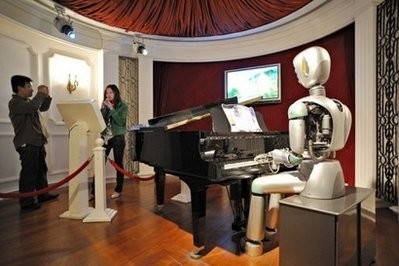 File photo shows a woman singing a karaoke song accompanied by piano played by a robot at the Science and Technology Museum in Shanghai. .