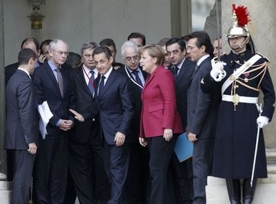 French President Nicolas Sarkozy, center, with German Chancellor Angela Merkel, third right, and EU President Herman Van Rompuy, second left, leave the crisis summit on Libya at the Elysee palace in Paris, Saturday, March, 19, 2011.