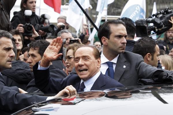 Italy's Prime Minister Silvio Berlusconi gestures as he leaves the Justice Palace in Milan March 28, 2011