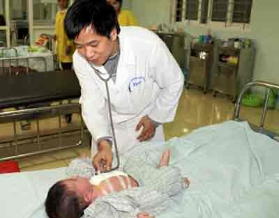 Doctor examining child after open surgery (Photo: Tuoi Tre)