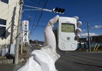This handout picture released by Greenpeace and taken on March 27, 2011 shows a Greenpeace team member holding a Geiger counter displaying radiation levels of 7.66 micro Sievert per hour in Iitate city, Fukushima. AFP