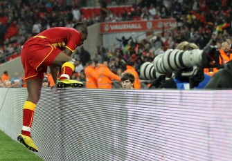AFP - Asomoah Gyan climbs over the advertising boards as he celebrates scoring his team's equaliser against England