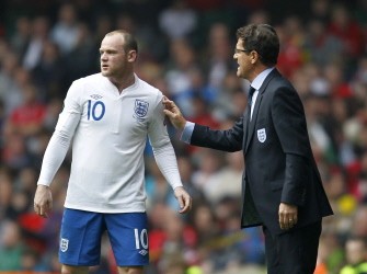 England's Italian Manager Fabio Capello (R) gestures to England's Wayne Rooney during the match against Wales during a Euro 2012, Group G qualifying football match at the Millenium Stadium, Cardiff, Wales on March 26, 2011. AFP