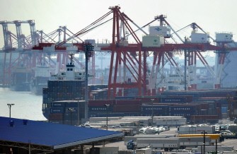 AFP - This picture taken on March 30, 2011 shows ships and containers at a wharf in the Tokyo Port.
