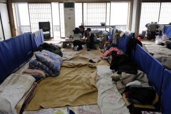 This picture taken on March 28, 2011 shows Tomokoi Sato, 55, (C) chatting with children of other families who were evacuated from Fukushima at her makeshift shelter in Yokote city, Akita prefecture.
