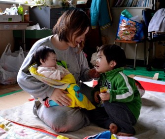 Twenty-two year-old mother Yoko Kamata sits with her baby Yuzuyu (L) and son Seiga (R) at a shelter in Kamaishi city in Iwate prefecture on March 29, 2011. AFP