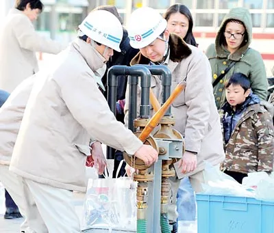 Người dân thị trấn Koriyama, tỉnh Fukushima nhận những túi nước cứu trợ. Ảnh: AFP