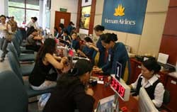 Clients buy airline tickets at Vietnam Airlines headquarters in Ha Noi. Ceiling fares on domestic routes may increase by 20 per cent due to the depreciation of the dong and fuel price hikes.(Photo:VNA)
